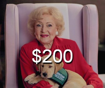 Betty White holding a guide dog puppy